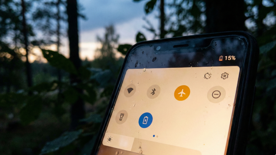 Doğada acil durum için uçak modu aktif edilmiş, düşük şarjlı akıllı telefon ekranı