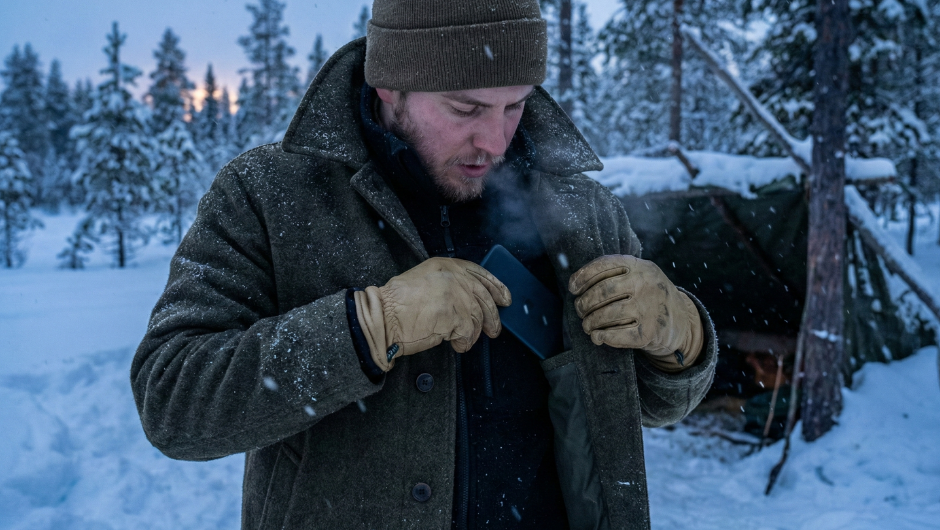 Soğuk hava koşullarında pil ömrünü korumak için akıllı telefonu vücut ısısına yakın bir iç cebe yerleştiren kişi